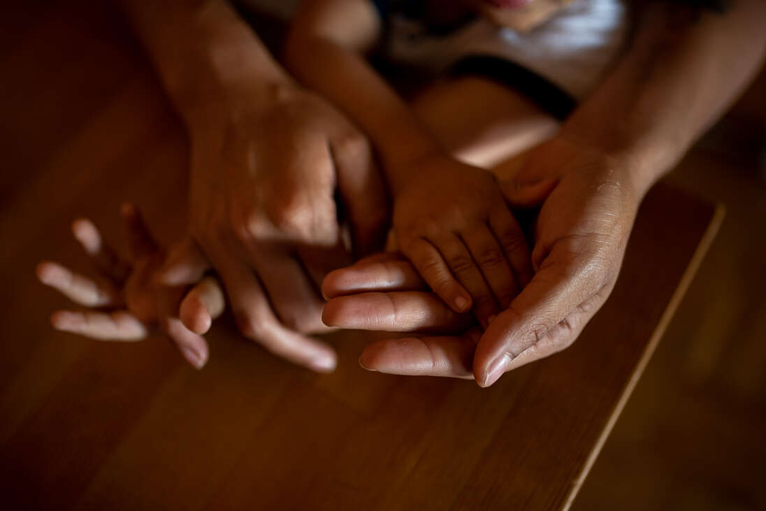 WMN cikk borító fotója. Egymásba kapaszkodó kezek.